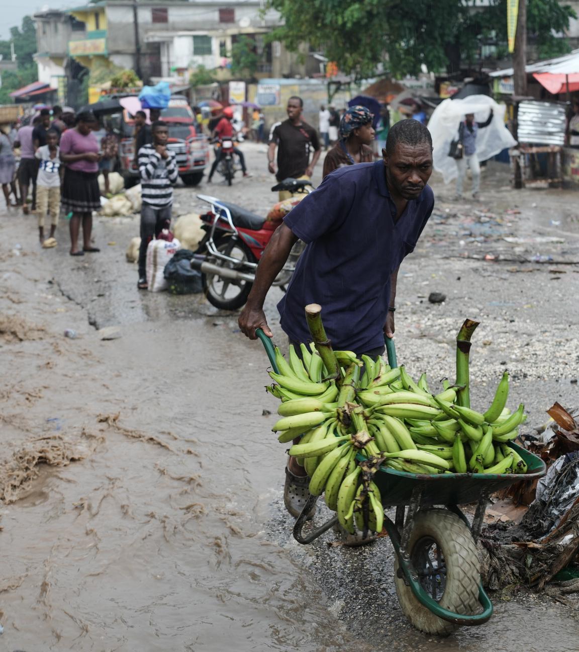 Ein Mann schiebt eine Schubkarre durch eine überflutete Straße nach dem Durchzug des Hurrikans «Melissa». 