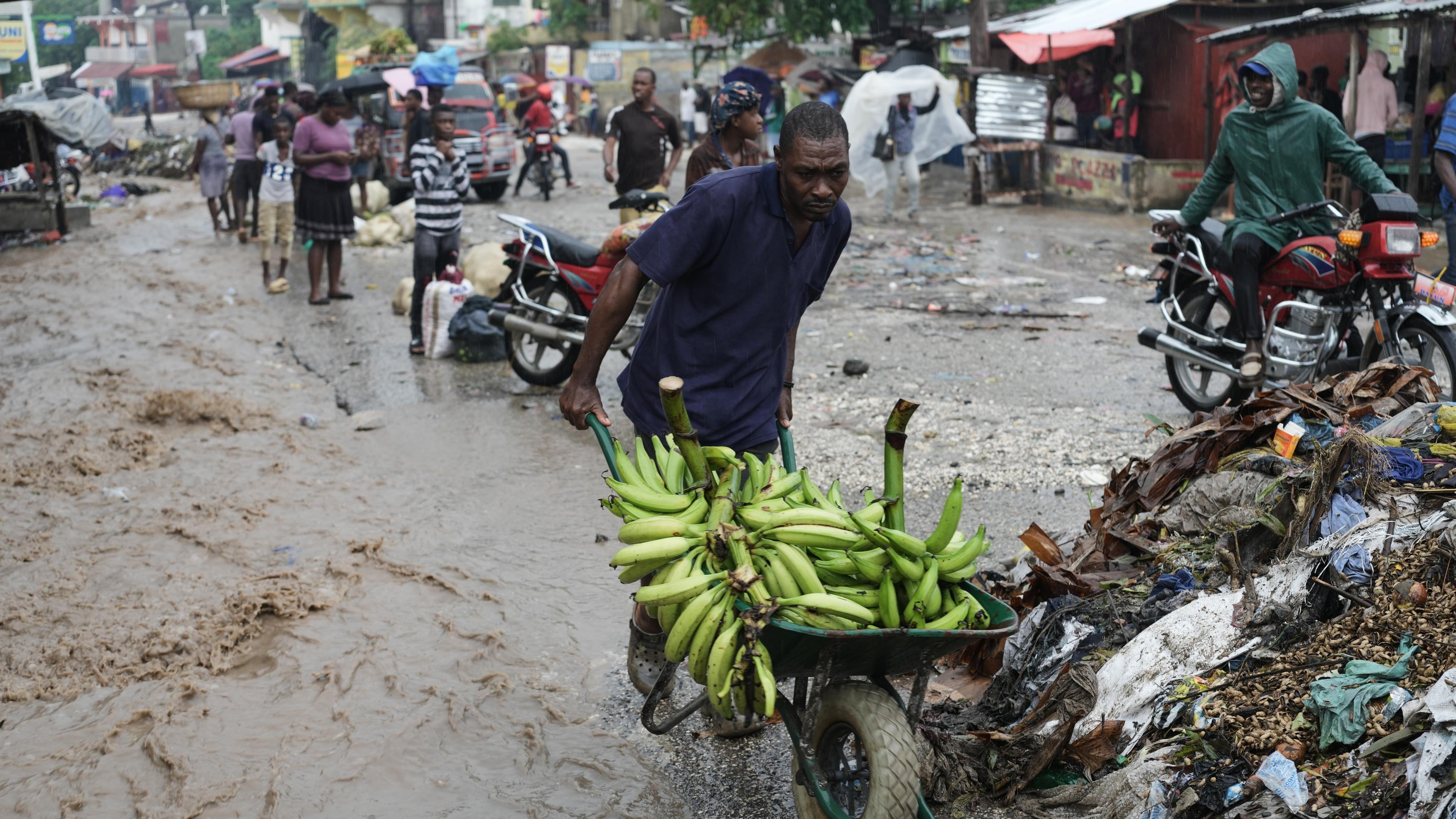 Ein Mann schiebt eine Schubkarre durch eine überflutete Straße nach dem Durchzug des Hurrikans «Melissa». 