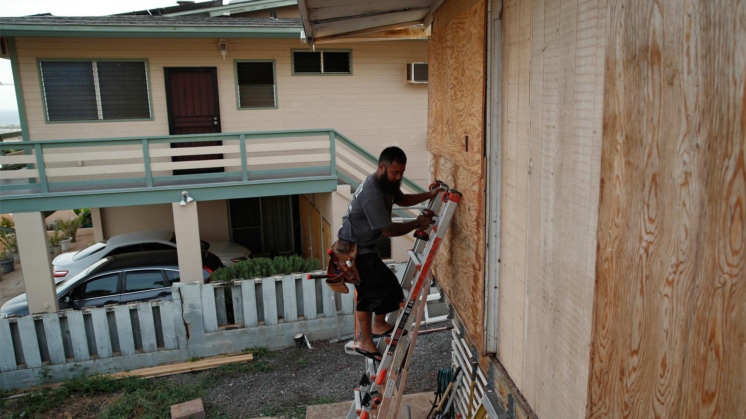 Kaipo Popa sichert Sperrholz, um Fenster auf einem Haus in der Vorbereitung für Hurrikan Lane am 23.08.2018 in Kapolei (USA)