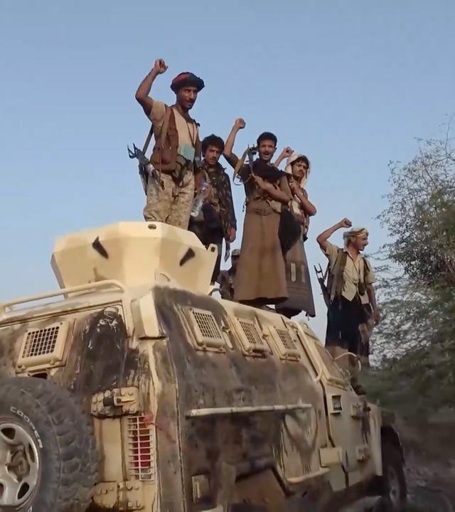 Kämpfer der Huthi-Miliz strecken ihre Arme in die Luft. 