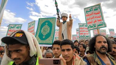 Ein Junge gestikuliert hält ein Modell eines Raketenwerfers in der Hand, während Anhänger der jemenitischen Huthis sich zu einer antiisraelischen Kundgebung versammeln. 