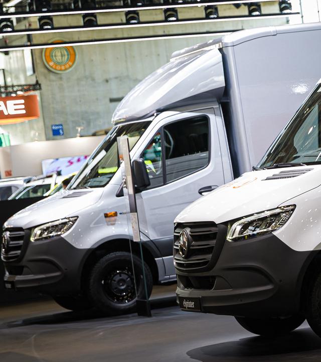 Verschiedene Nutzfahrzeuge werden am Stand von Mercedes-Benz auf der Messe IAA Transportation präsentiert