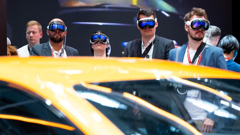 Besucher schauen sich während der Eröffnung der Internationalen Automobil-Ausstellung (IAA Mobility) den Messestand von Mercedes an und tragen dabei eine VR-Brille von Apple.