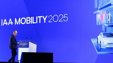 Bayern, München: Bundeskanzler Merz steht auf der Bühne bei der Eröffnung der Automesser IAA.