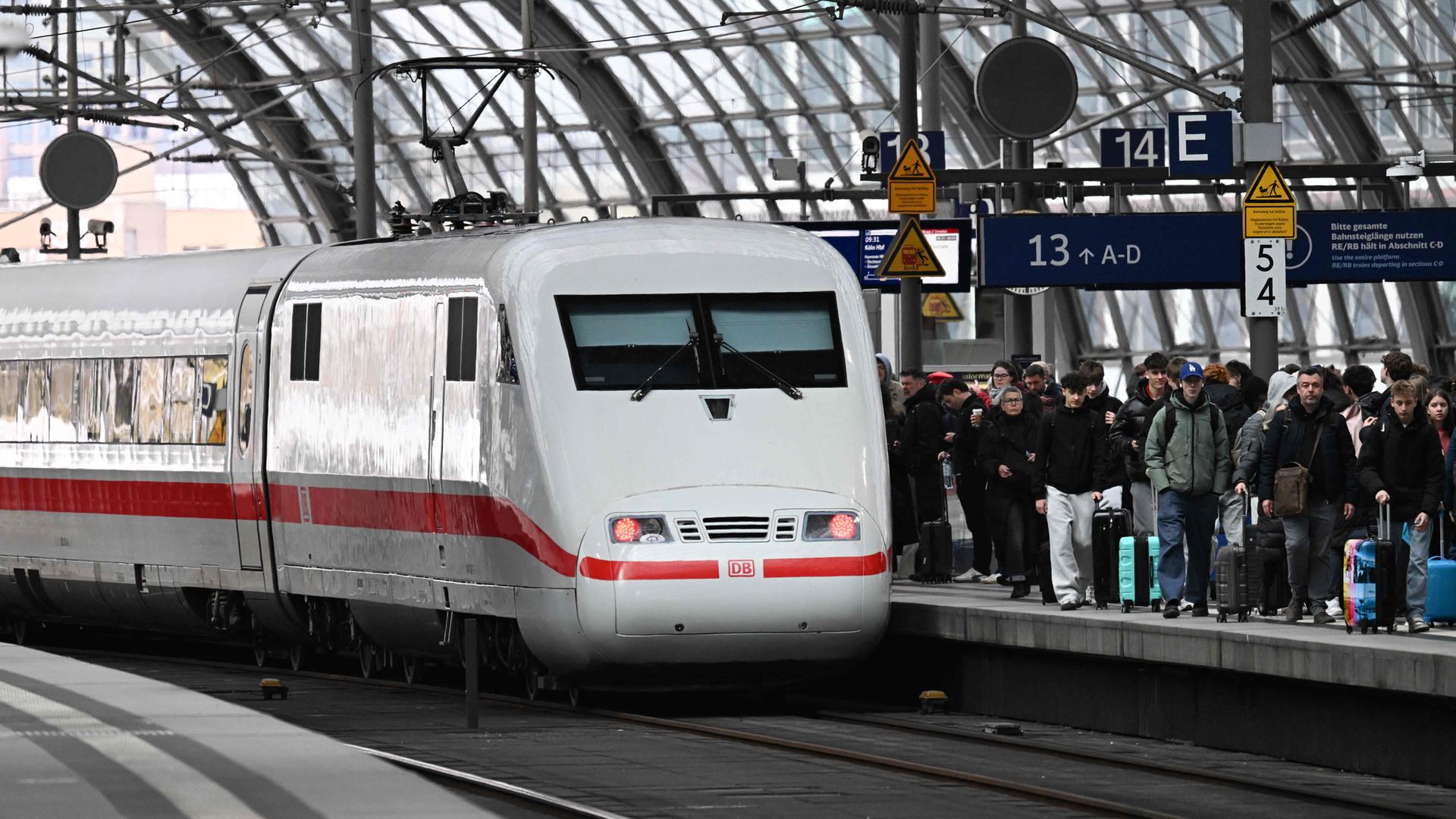 Ein ICE steht auf einem Gleis im Berliner Hauptbahnhof. Der Bahnsteig dahinter ist gefüllt mit Reisenden.
