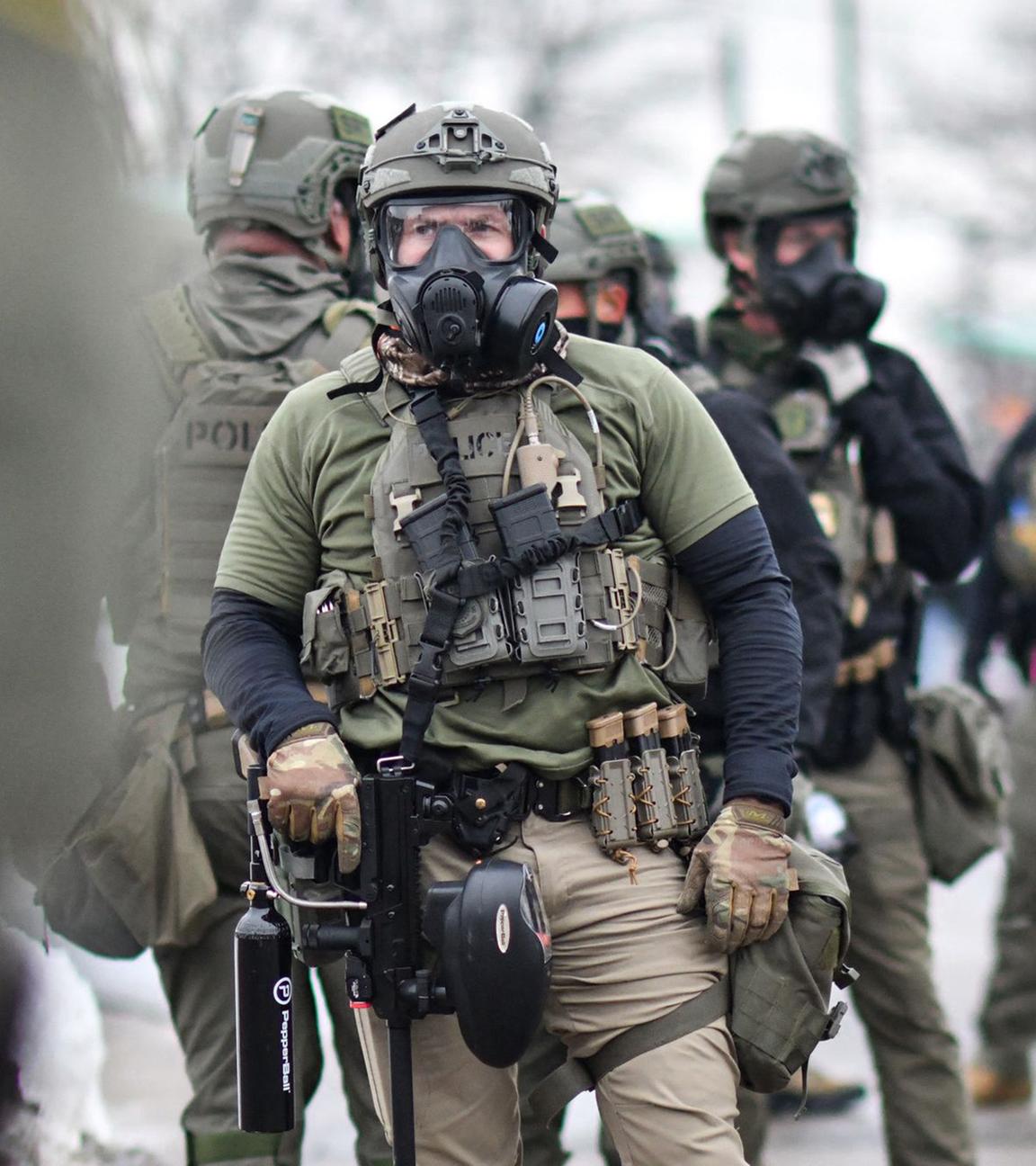 Bundesbeamte stehen Wache, während sich am 8. Januar 2026 Demonstrierende vor dem Bishop Henry Whipple Federal Building in Saint Paul, Minnesota, versammeln.