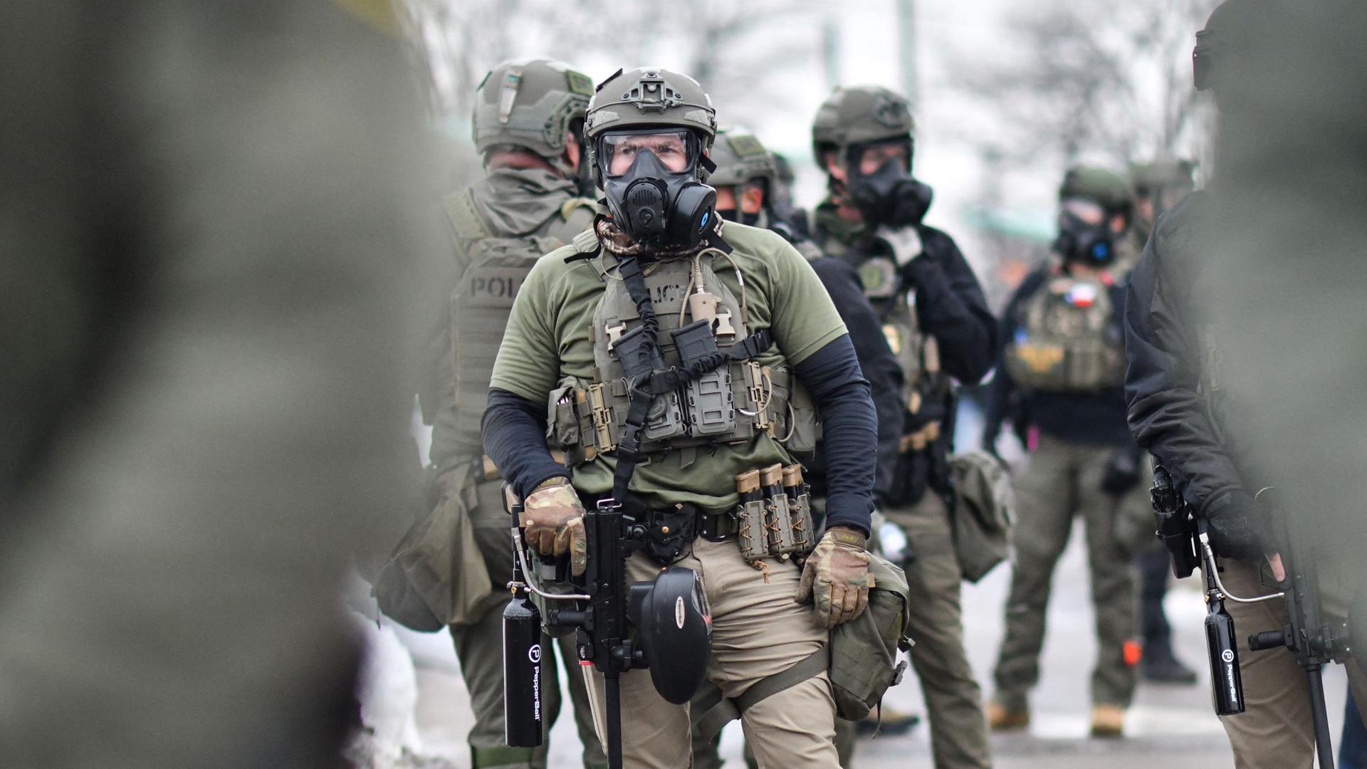 Bundesbeamte stehen Wache, während sich am 8. Januar 2026 Demonstrierende vor dem Bishop Henry Whipple Federal Building in Saint Paul, Minnesota, versammeln.