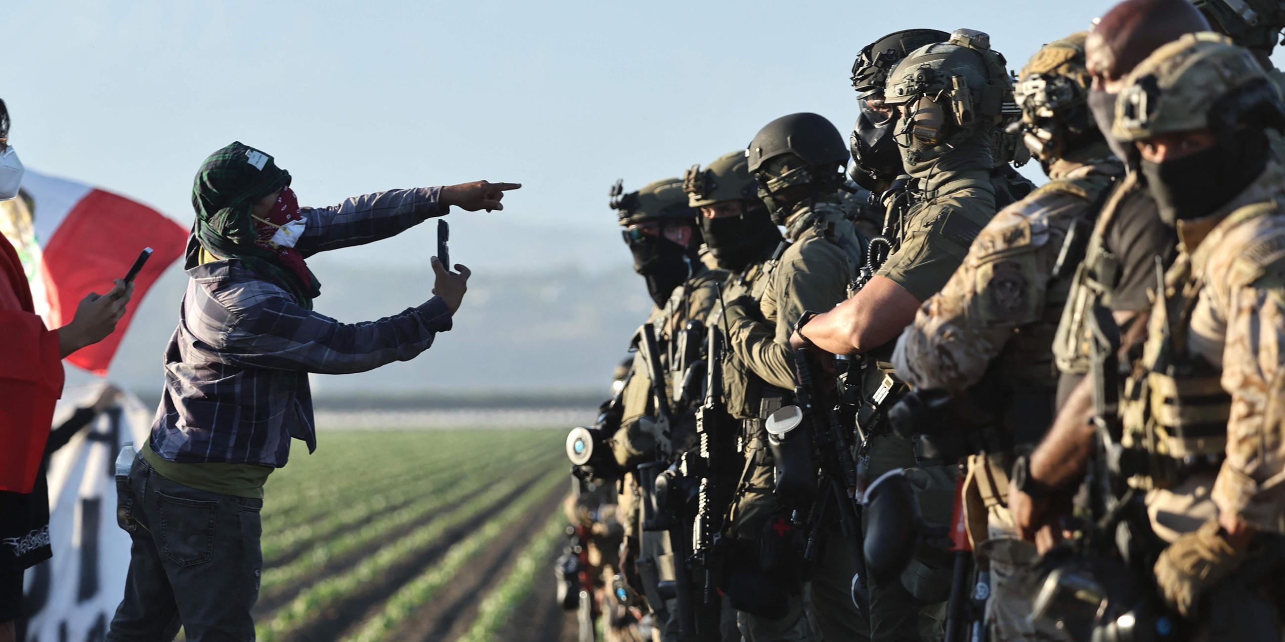 Bundesbeamte blockieren Protestierende nach einer ICE-Razzia auf einer nahegelegenen Cannabisfarm.