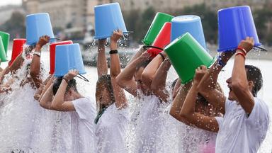 Das Bild zeigt viele Menschen, die sich einen Eimer mit Eiswasser über den Kopf schütten.