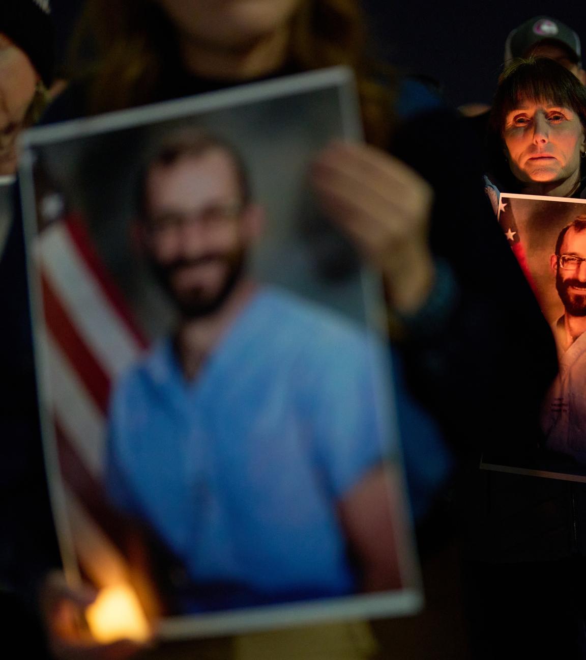 Menschen halten Fotos während einer Mahnwache für Alex Pretti hoch, der von Bundesbeamten in Minneapolis erschossen wurde.