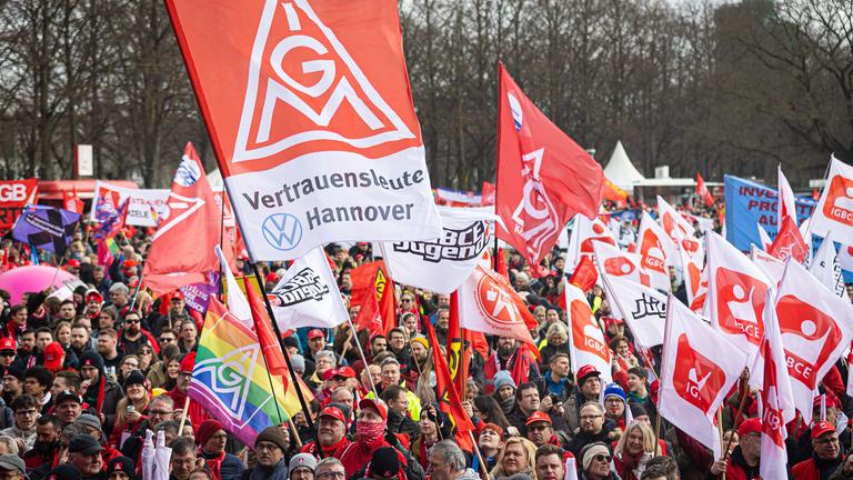 15.03.2025, Niedersachsen, Hannover: Demonstranten nehmen am bundesweiten Aktionstag der IG Metall teil und stehen im Georgengarten. 