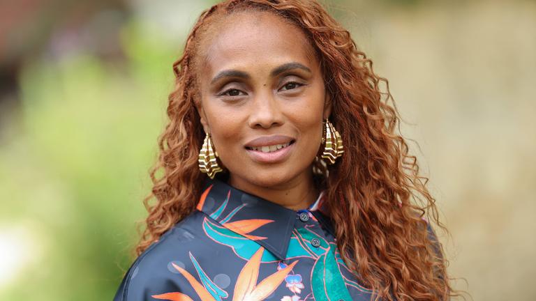 Junge schwarze Frau mit langen braunen Locken.