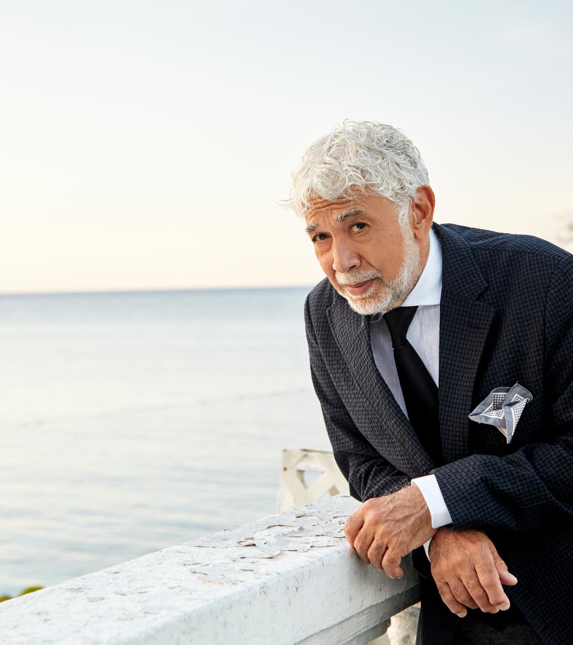 Der jamaikanische Jazzpianist Monty Alexander in mediterranem Flair, auf eine Balustrade gestützt, im Anzug. Dahinter das Meer, er schaut etwas verschmitzt-fragend in die Kamera.