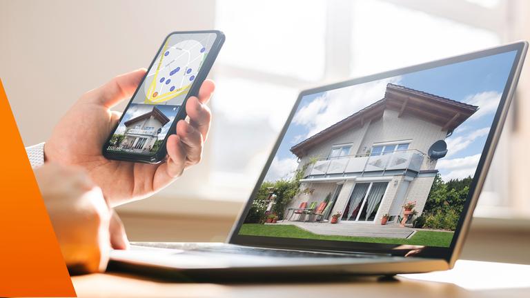 Haus auf einem Handy und am Rechner