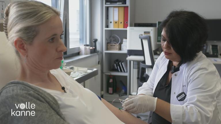 Frau bekommt von Ärztin Blut gemessen