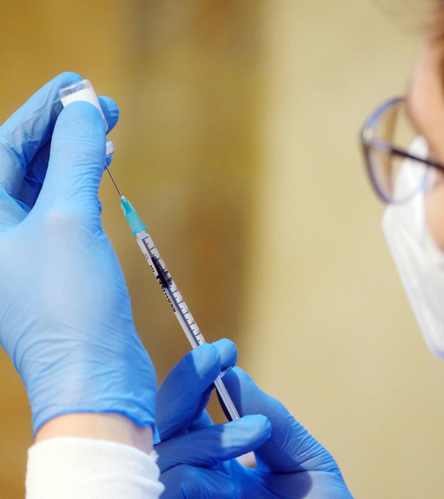 Medizinisches Personal dosiert Corona-Impfstoff