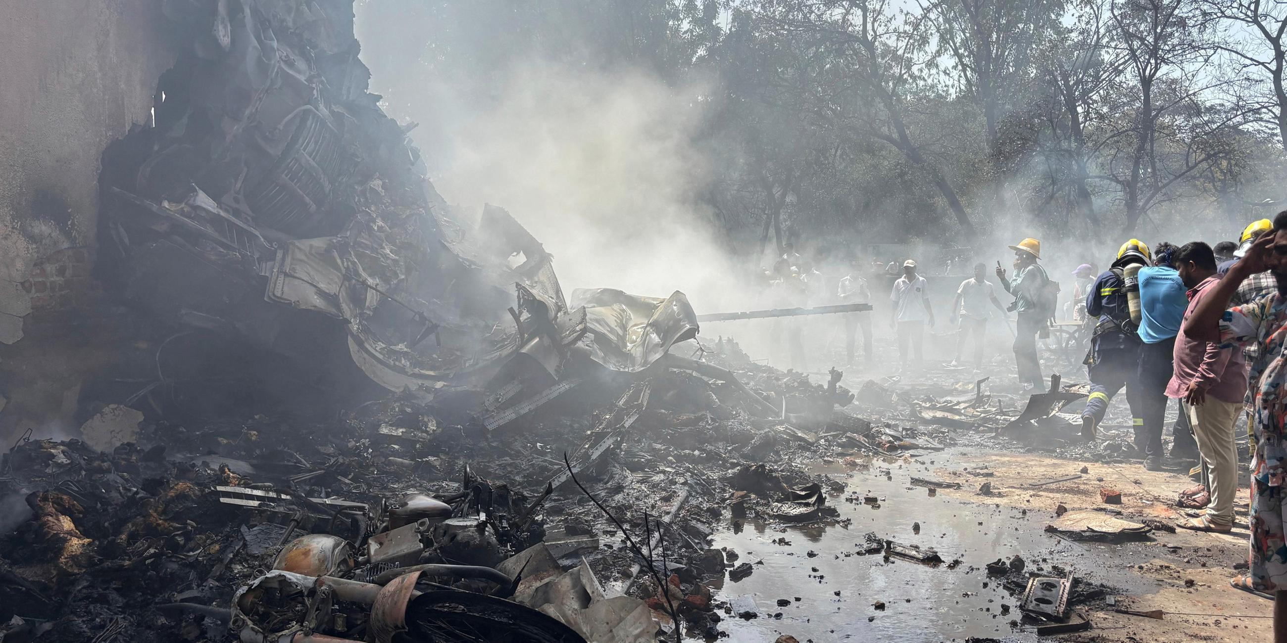 12.06.2025, Indien, Ahmedabad: Feuerwehrleute arbeiten an der Absturzstelle eines Flugzeugs in der nordwestlichen Stadt Ahmedabad im indischen Bundesstaat Gujarat