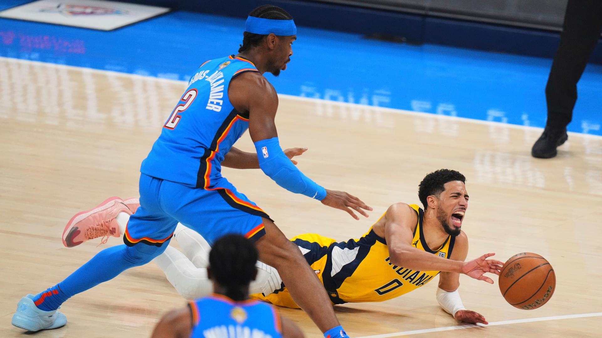 Tyrese Haliburton (0), Guard der Indiana Pacers, fällt während der ersten Hälfte von Spiel 7 der NBA-Finalserie gegen die Oklahoma City Thunder mit einer Verletzung auf das Spielfeld.