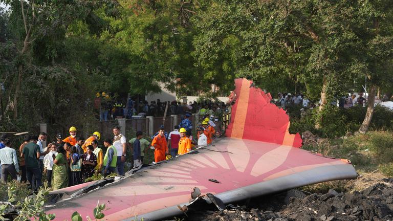 Menschen stehen um die Trümmer eines Flugzeugs herum, nachdem es in der nordwestlichen indischen Stadt Ahmedabad im Bundesstaat Gujarat abgestürzt ist.