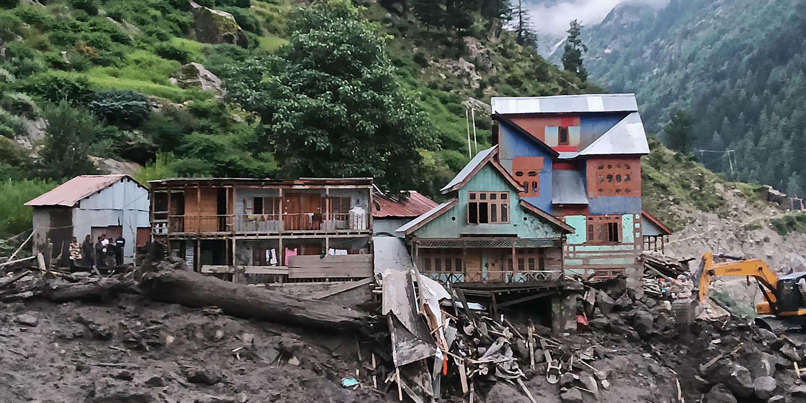TOPSHOT - Rescuers (L) inspect the site of a flashflood at a village in Kishtwar district on August 14, 2025.