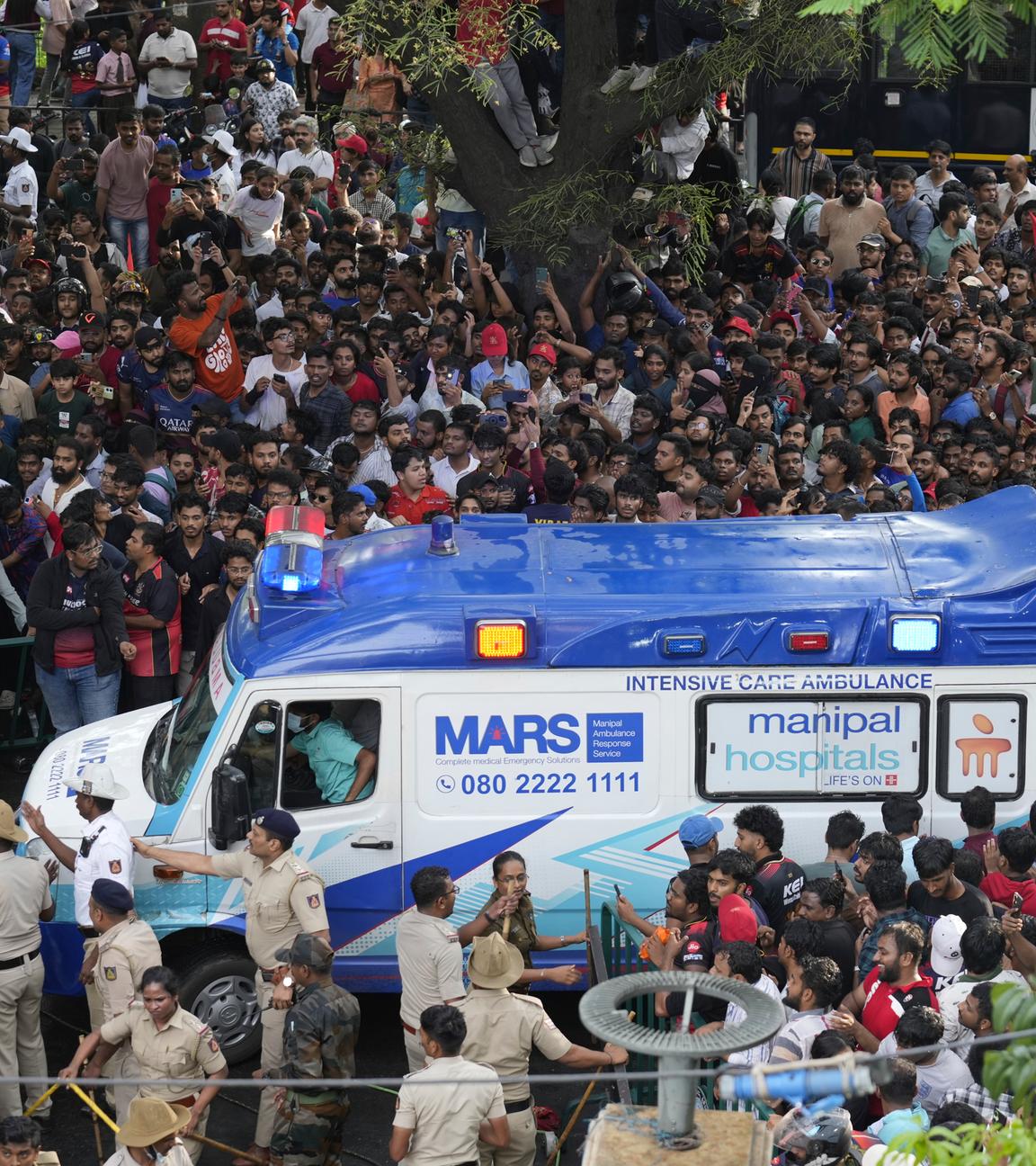 Ein Krankenwagen innerhalb einer Menschenmenge in Indien während der Meisterschaftsfeier der Royal Challengers