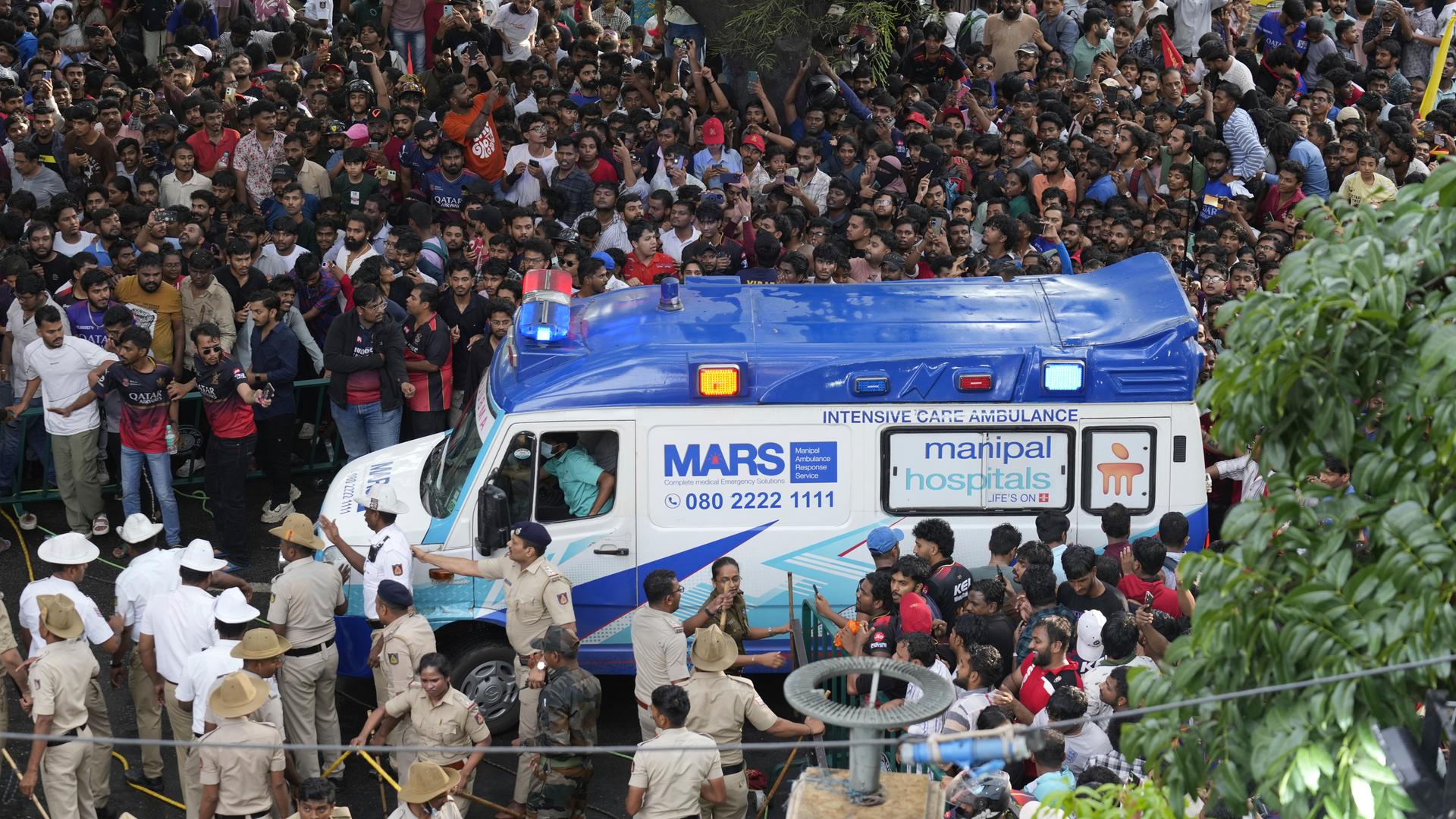 Ein Krankenwagen innerhalb einer Menschenmenge in Indien während der Meisterschaftsfeier der Royal Challengers