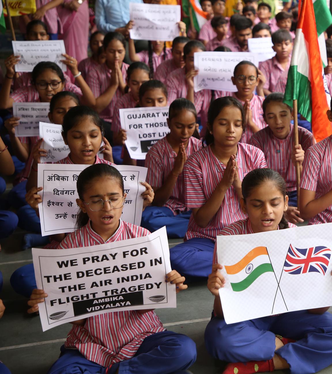 People hold banners and slogans as they take part in a prayer ceremony in india s Ahmedabad city.
