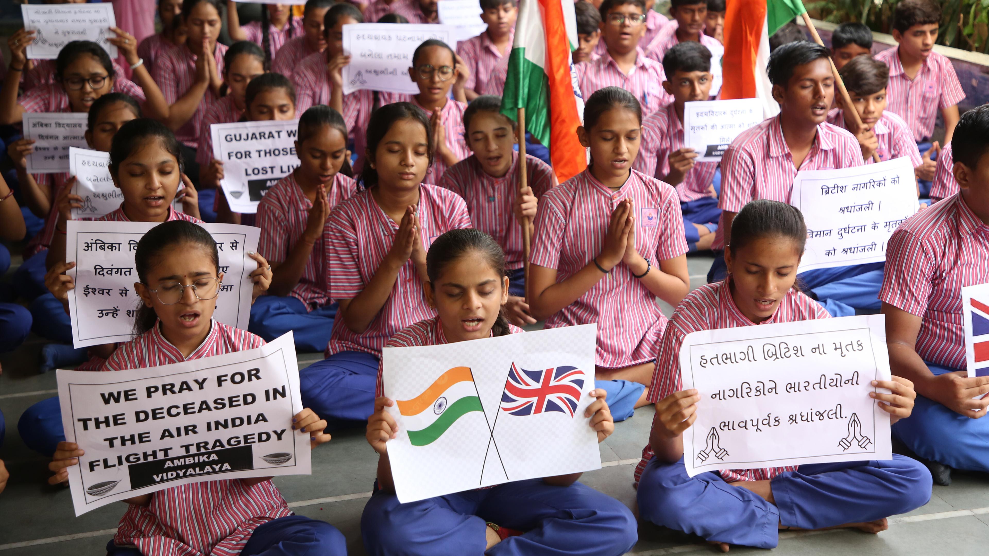 People hold banners and slogans as they take part in a prayer ceremony in india s Ahmedabad city.