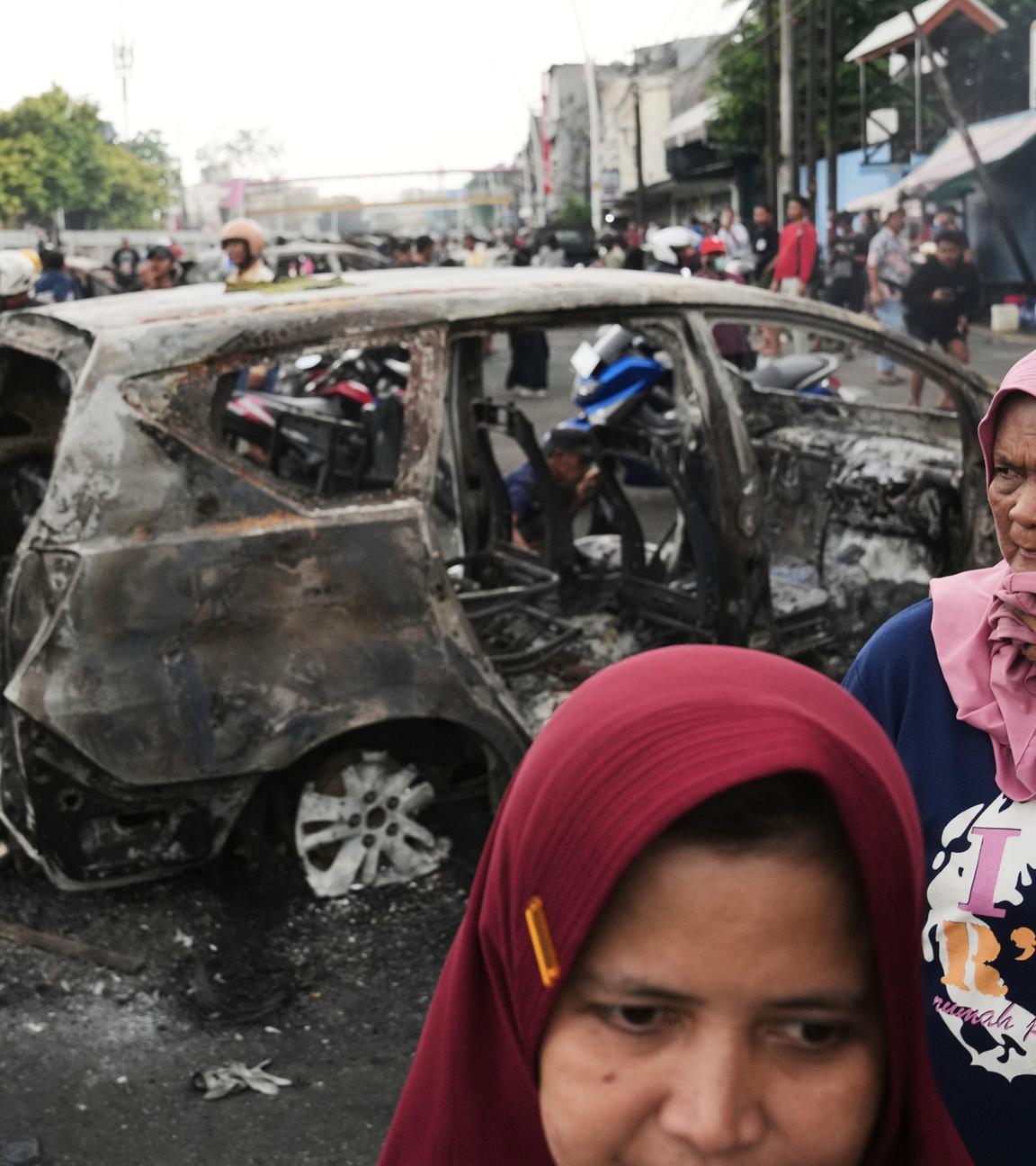 Menschen in Indonesien zwischen den Trümmern einer Demonstration