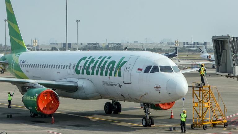 Mitarbeiter reinigen ein Flugzeug, nachdem der Flugbetrieb infolge des Ausbruchs des Vulkans Anak Krakatau eingestellt worden war