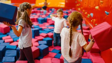 Kinder spielen mit weichen Würfeln.