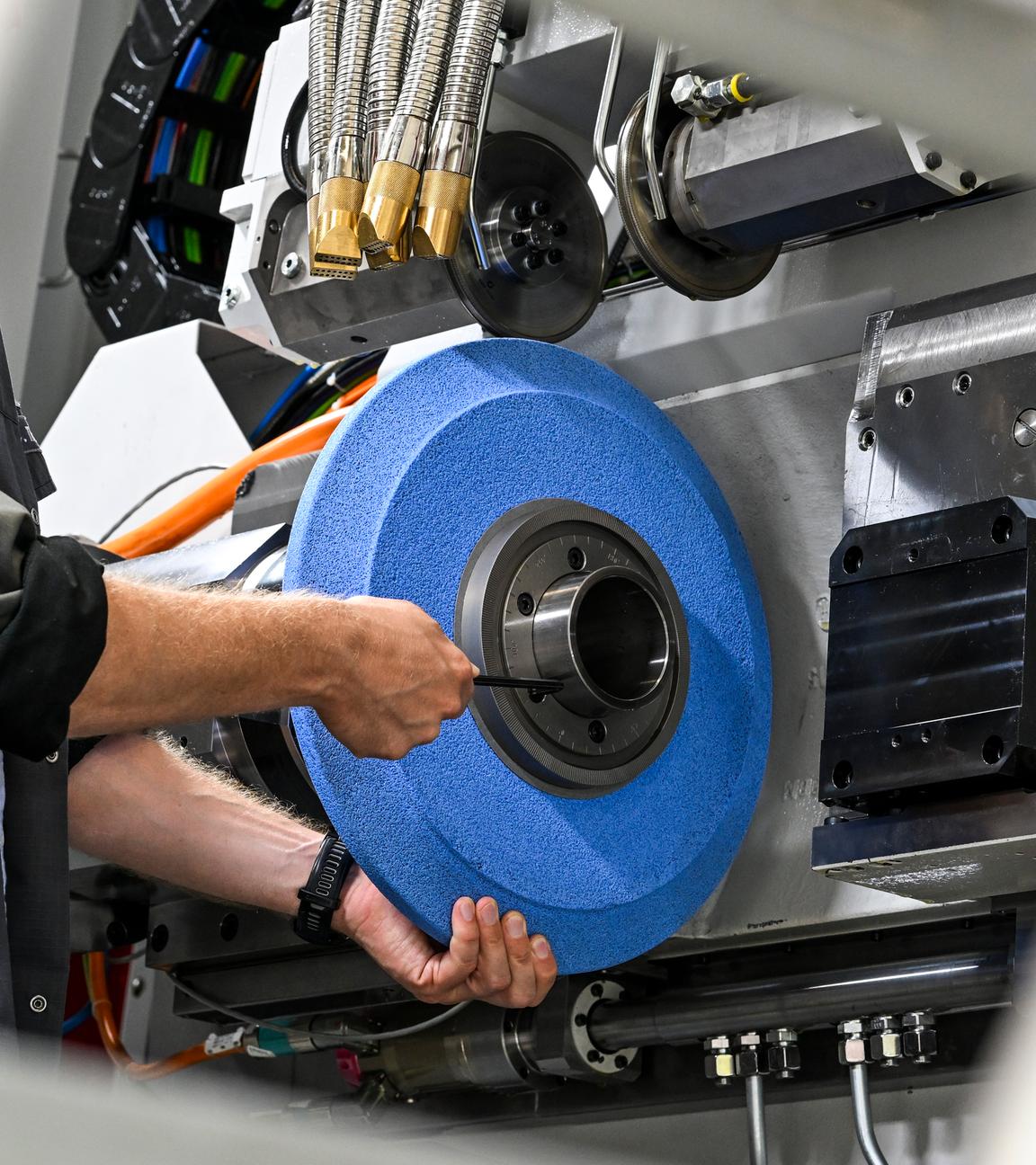 ARCHIV - 29.08.2024, Berlin: Eine Schleifscheibe wird in einer Zahnradprofilschleifmaschine befestigt. (zu dpa: «Ifo: Unternehmen planen mehr Kurzarbeit und Jobabbau») Foto: Jens Kalaene/dpa +++ dpa-Bildfunk +++