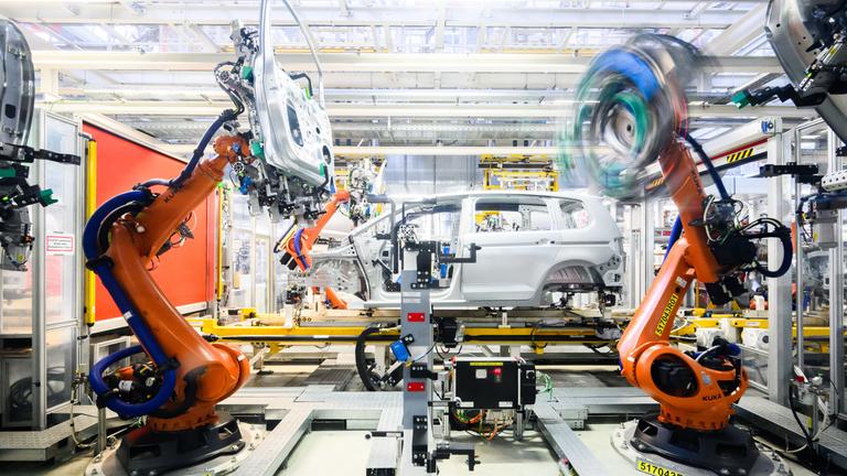 Niedersachsen, Wolfsburg: Roboter montieren im VW Stammwerk im Karosseriebau Türen an einen Neuwagen Volkswagen.