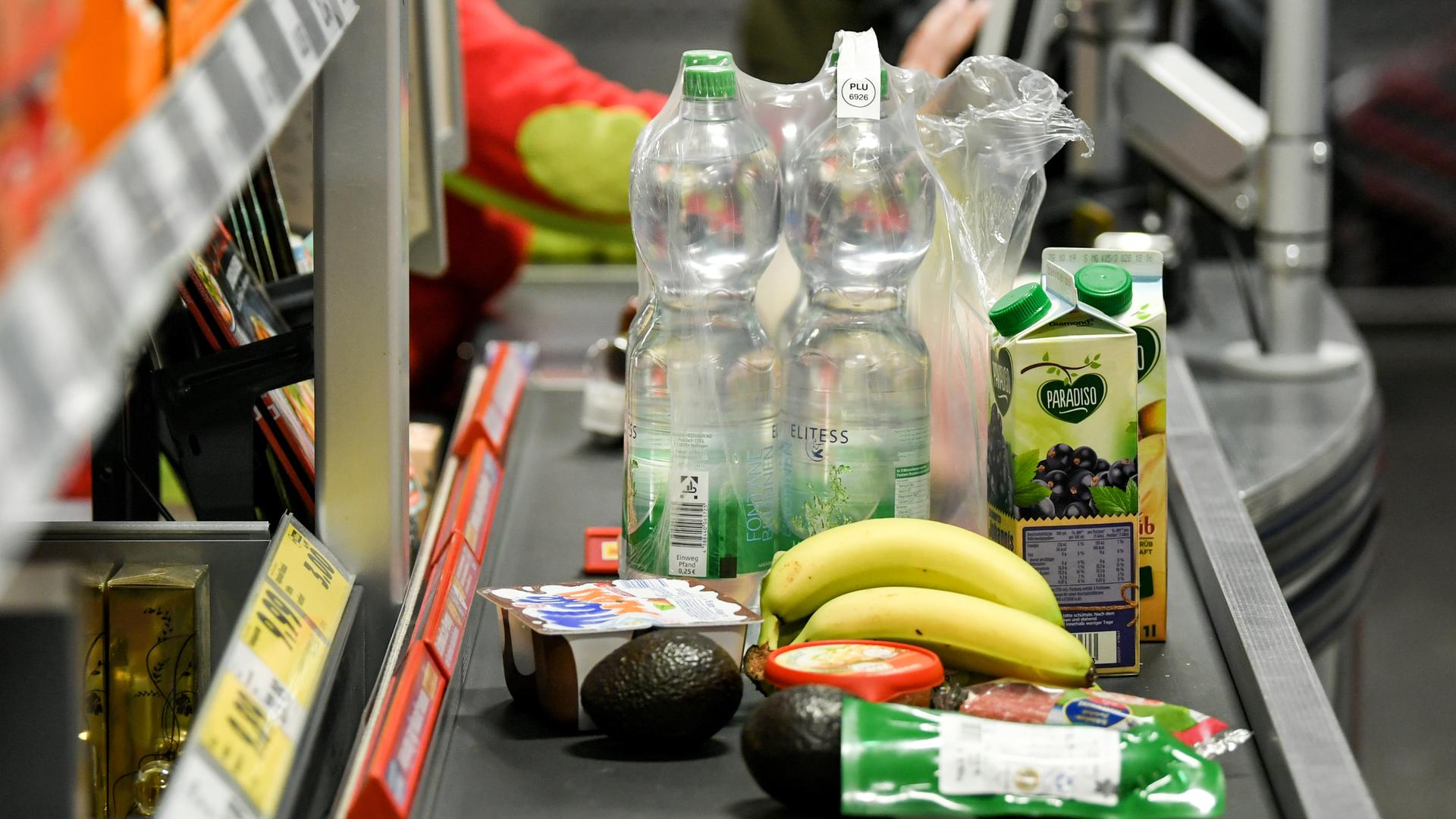 Verschiedene Lebensmittel stehen auf dem Band einer Supermarktkasse