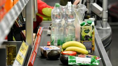 Verschiedene Lebensmittel stehen auf dem Band einer Supermarktkasse