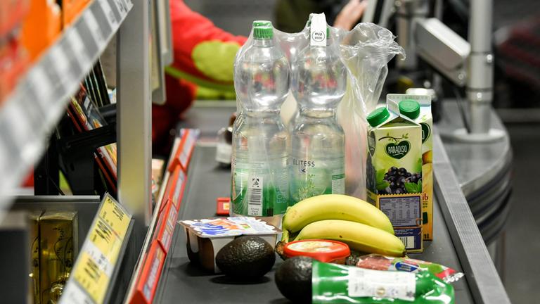 Verschiedene Lebensmittel stehen auf dem Band einer Supermarktkasse