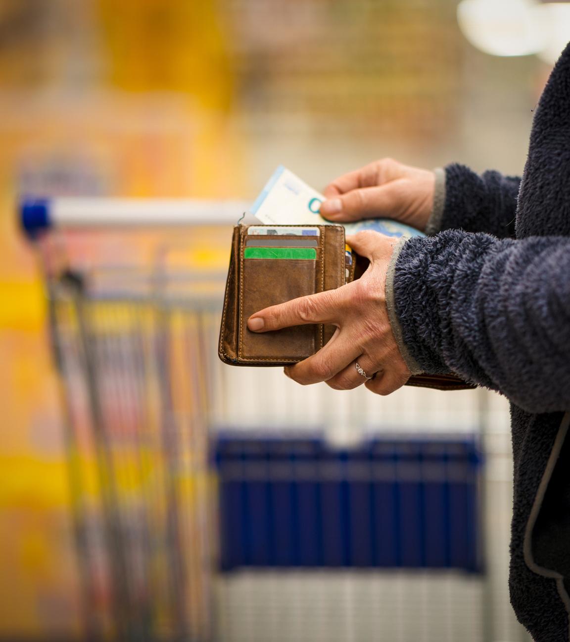 Frau zählt im Supermarkt ihr Geld