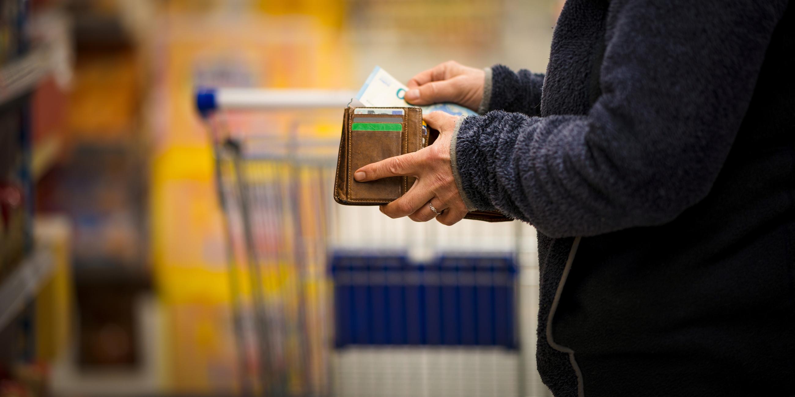 Frau zählt im Supermarkt ihr Geld