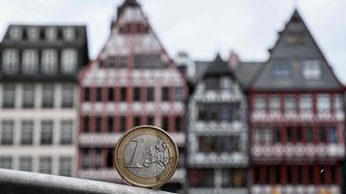 Eine Ein-Euro-Münze vor einer Hausfassade in Frankfurt am Main.