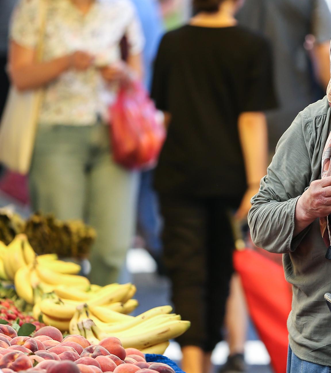 Symbolbild: Eine Frau zählt Geld auf dem Markt