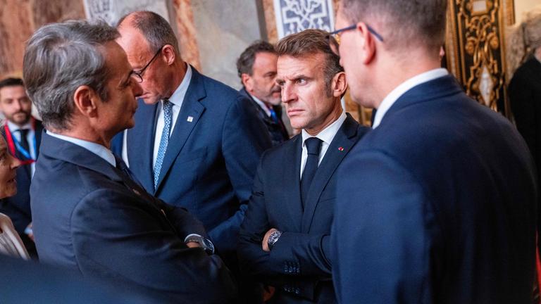 Greece's Prime Minister Kyriakos Mitsotakis (L) and France's President Emmanuel Macron (2ndR) talk prior to the first session of an Informal Meeting of EU Heads of State and Government.