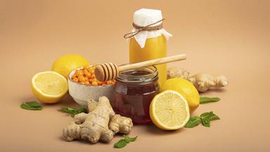 Lebensmittel zur Stimulation des Immunsystems, Sanddornbeeren, Zitronen, Minze, Ingwer, Honig im Glasgefäß.
