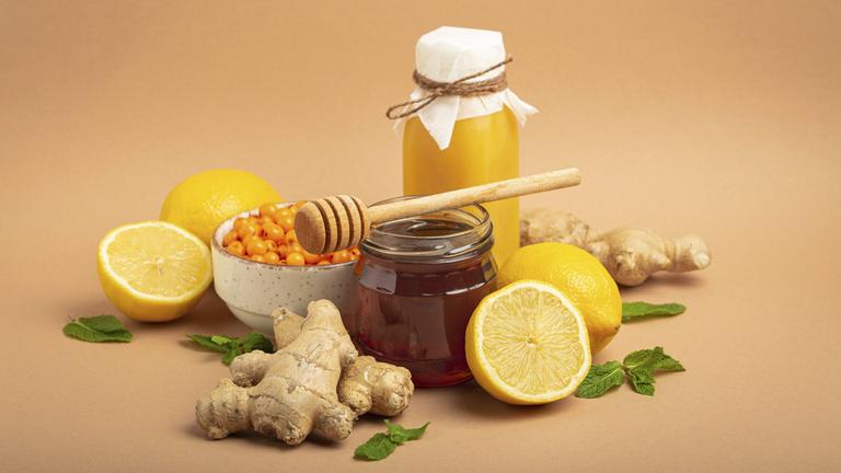 Lebensmittel zur Stimulation des Immunsystems, Sanddornbeeren, Zitronen, Minze, Ingwer, Honig im Glasgefäß.