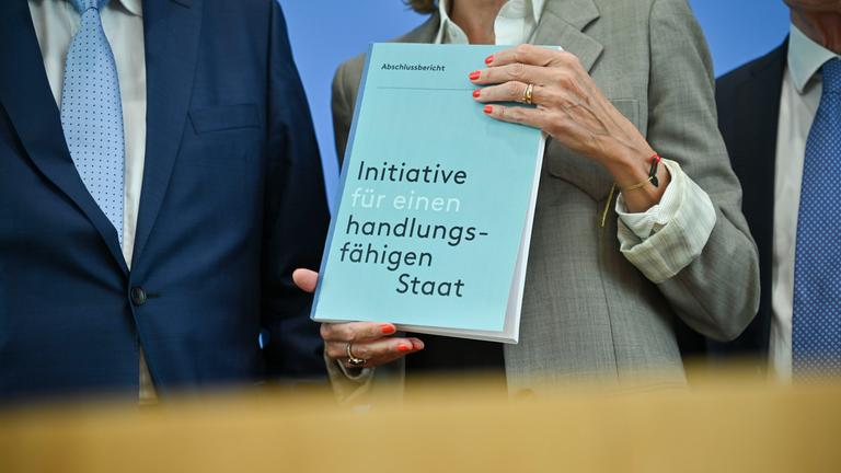 Peer Steinbrück (l-r), Ministerpräsident und Bundesminister a.D., Julia Jäkel, Managerin und Aufsichtsrätin, Thomas de Maizière, Bundesminister a.D., und Andreas Voßkuhle, ehemaliger Präsident des Bundesverfassungsgerichts, halten den Abschlussbericht der «Initiative für einen handlungsfähigen Staat» vor einer Pressekonferenz in der Bundespressekonferenz in den Händen.