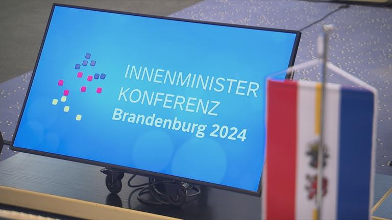 Bildschirm mit Anzeige: Innenministerkonferenz Brandenburg 2024