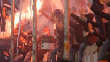 Blick von der Seite auf eine Tribüne: Ultras vom FC St.Pauli zünden Pyrotechnik während des Spiels gegen den FC Hansa Rostock.