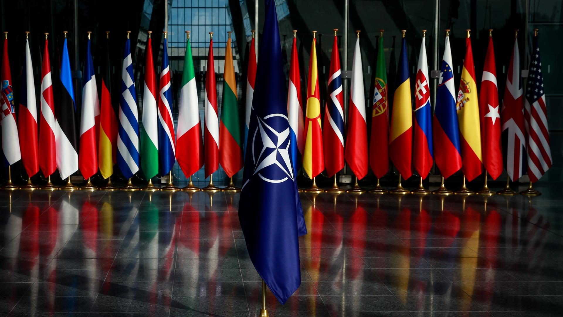 NATO-Flagge, die vor den Flaggen der Mitgliedsstaaten des Bündnisses platziert ist.