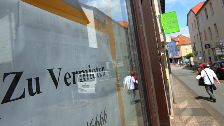 Ein Mann geht an einem Geschäft vorbei, das zu vermieten ist
