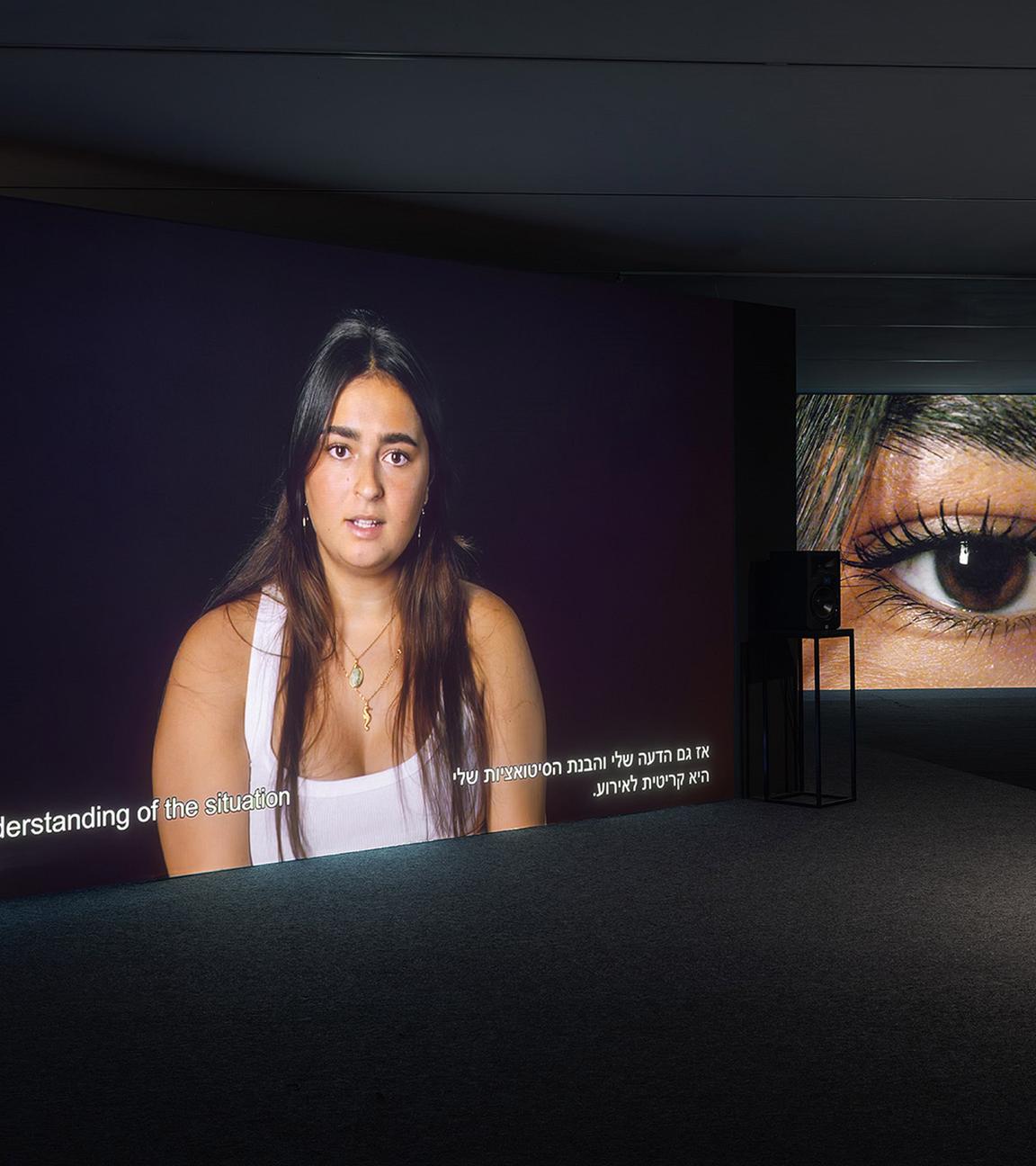 In einem dunklen Raum wird das Bild von einer jungen Frau an die Wand projiziert, in einem Nebenraum sieht man ein Großbild von ihrem Auge.