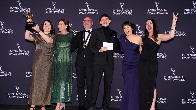 Anke Lindemann (l), Ralf Kukula (3.v.l), Gewinner in der Kategorie «Kids: Factual & Entertainment» für «Auf Fritzis Spuren - Wie war das so in der DDR?», erscheinen im Presseraum während der 53. International Emmy Awards im New York Hilton Midtown